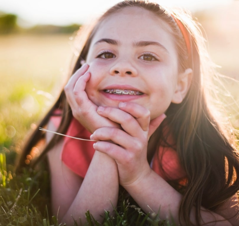 young girl with braces in a meadow
